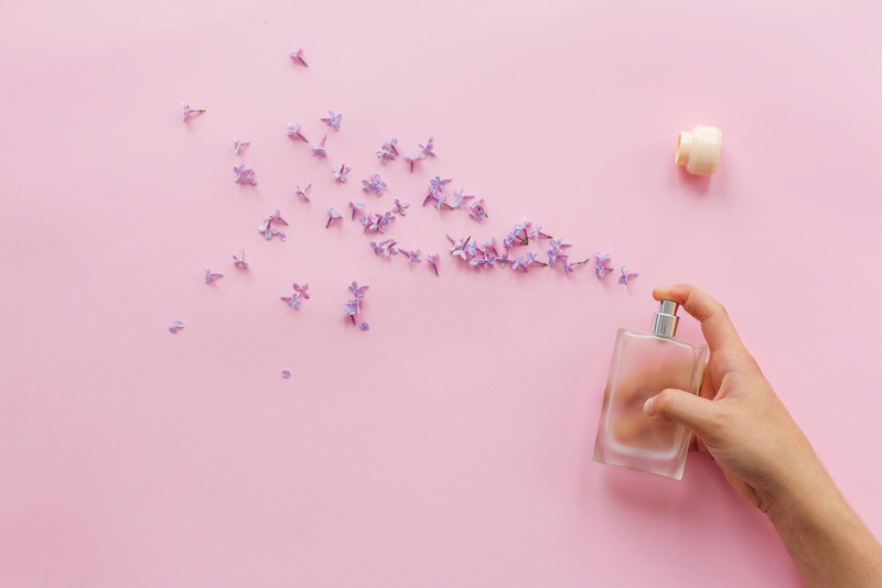 Perfumery and Floral Scent Concept. Hand Holding Stylish Bottle